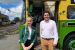 Photo of Huw and Sarah in front of bus