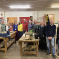 Huw stood with members of Bexhill Men's Shed around workbenches and tools