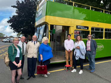 Photo of Huw, Caroline Ansell and Pevensey parish council in front of bus